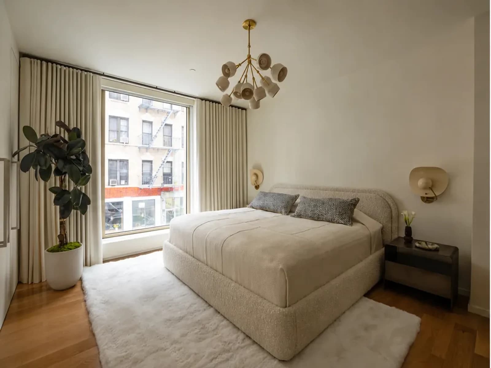Real bedroom before an AI redesign, with an upholstered bed beside a large window