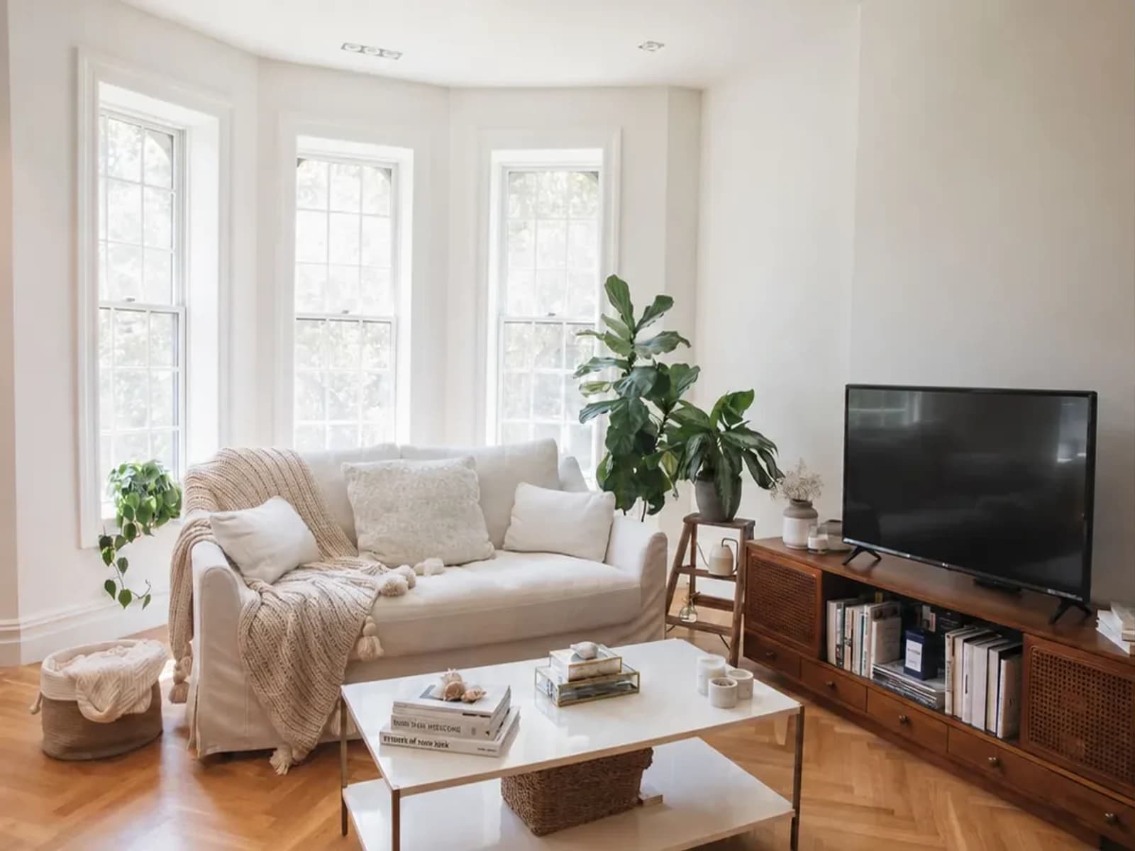 Original bright living room with a cream sofa in a three-window bay